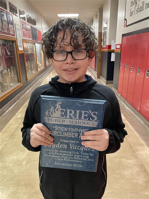 Jayden Vazquez, Strong Vincent's December Stairclimber, poses with his plaque.